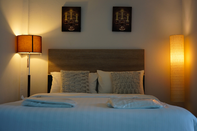 Udobna spavaća soba sa lampama koje emituju toplu svetlost